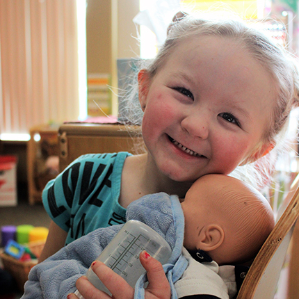 A girl holding a baby doll
