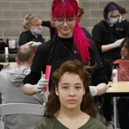 Cheyenne cuts the hair of her client Savannah
