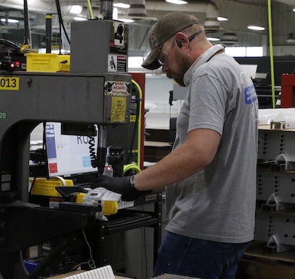 A worker operates machinery on a shop floor