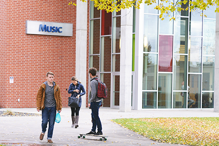 Students walking and infront of the Music building entrance
